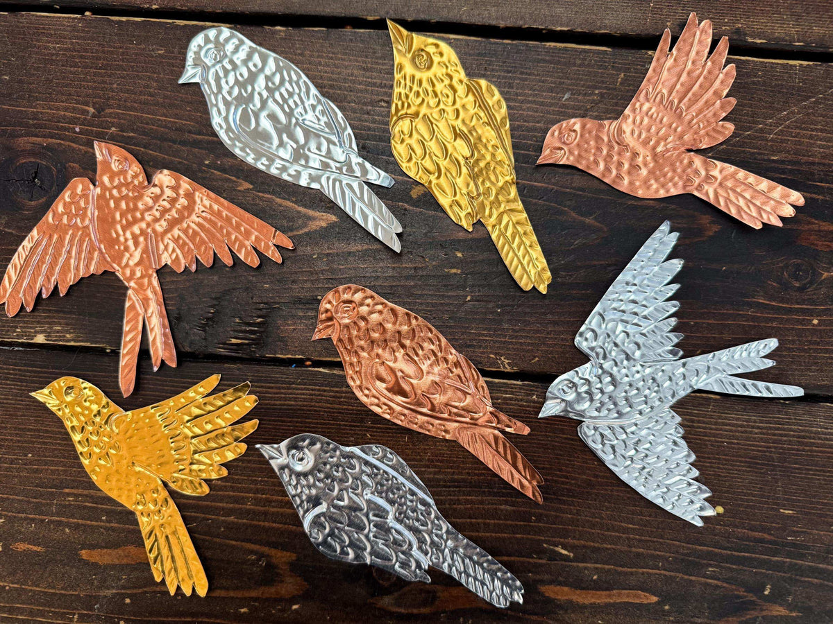 Metallic bird figurines in various colors on a wooden surface