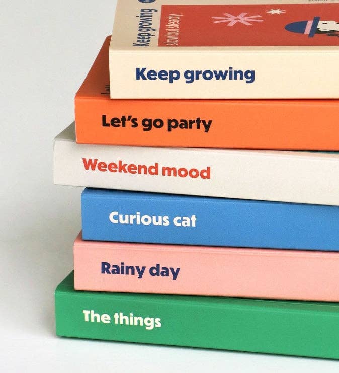 Stack of books with colorful titles on a light gray background