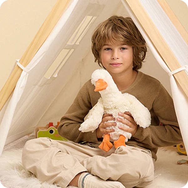 Child holding a plush toy inside a play tent