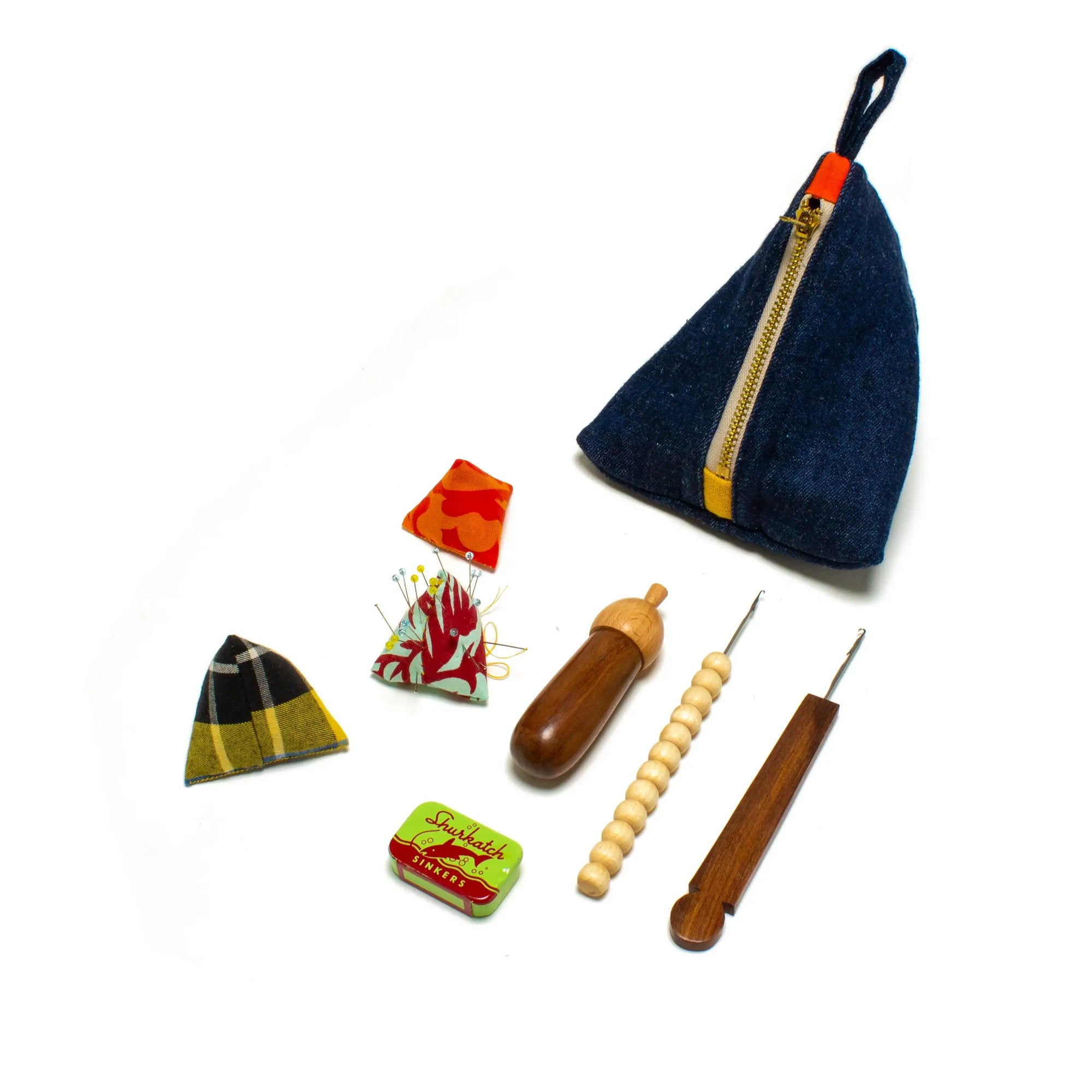 Collection of sewing tools and accessories including a denim pouch on a white background