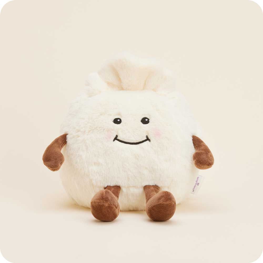 Plush toy dumplig with a smiley face on a beige background