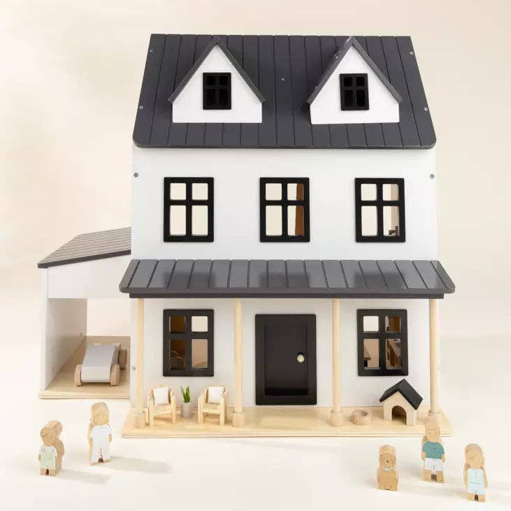 Wooden dollhouse with black roof and white walls on a light beige background