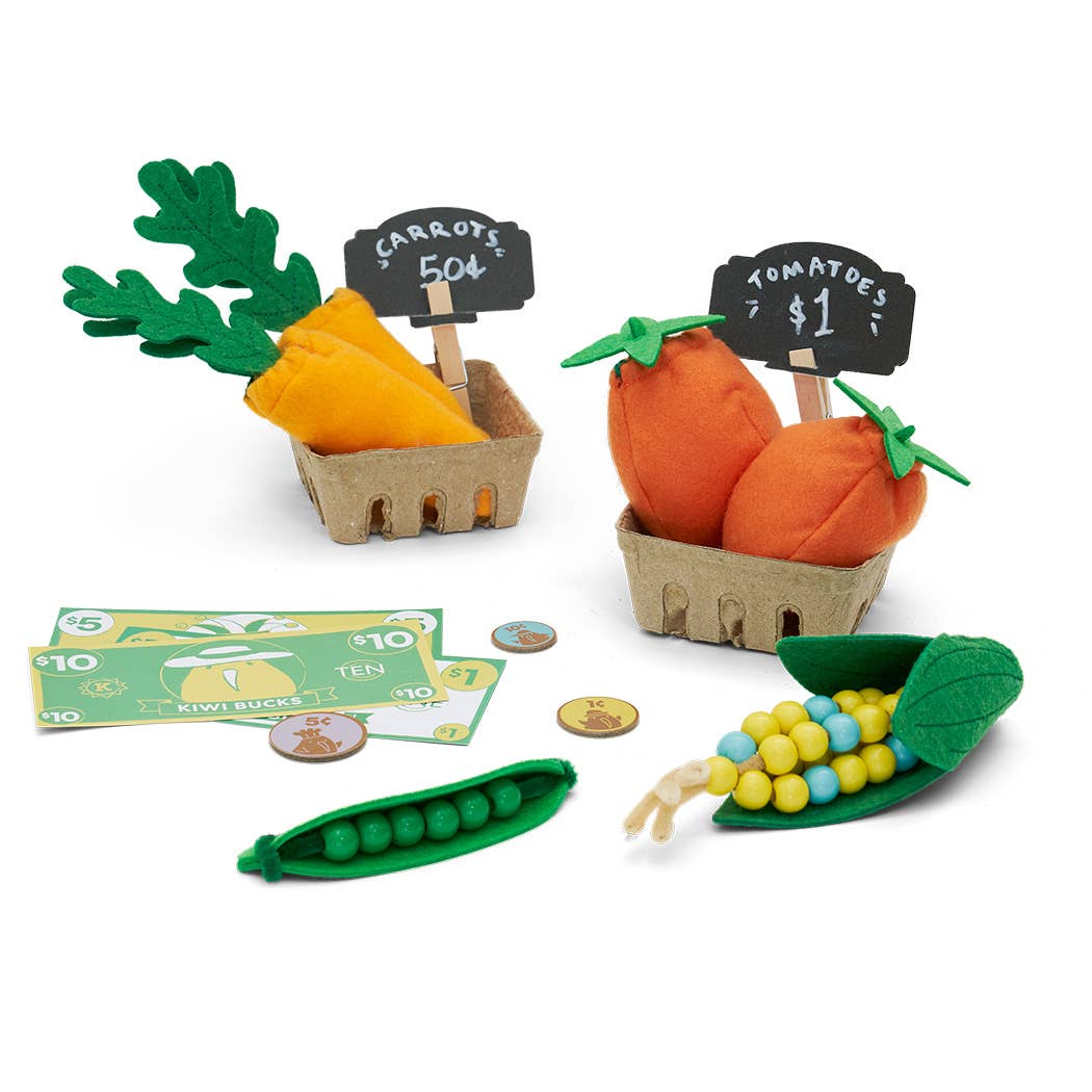 Toy vegetables including carrots, peas, and corn with price tags on a white background