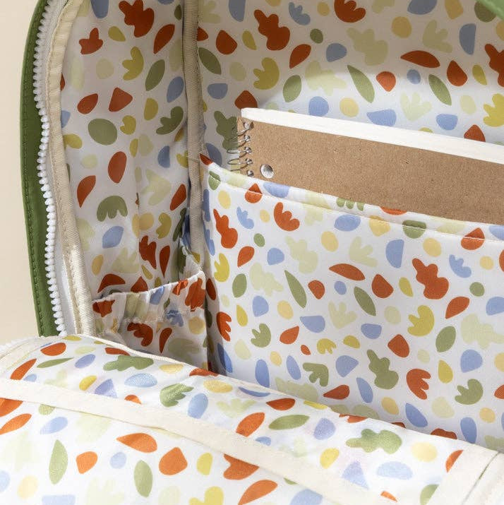 Colorful patterned fabric with a notebook inside, on a beige background