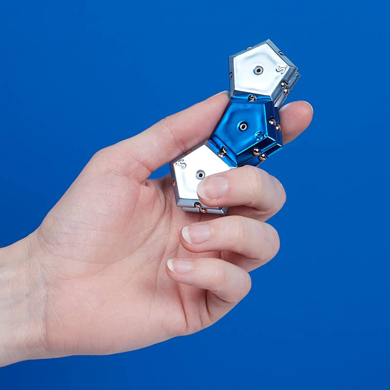 Hand holding a blue and silver mechanical device against a blue background
