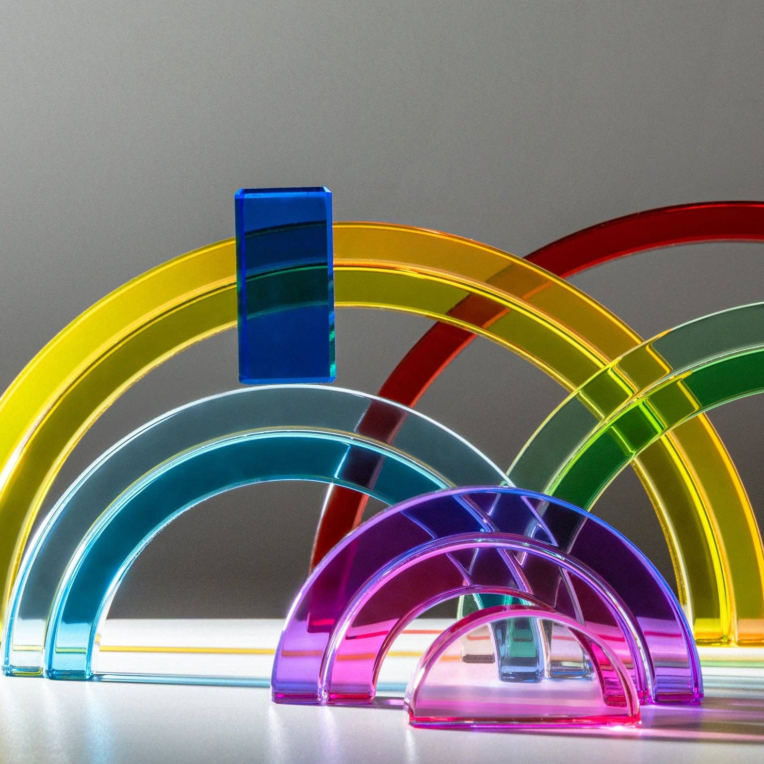 Set of colorful rainbow-shaped objects on a gray background
