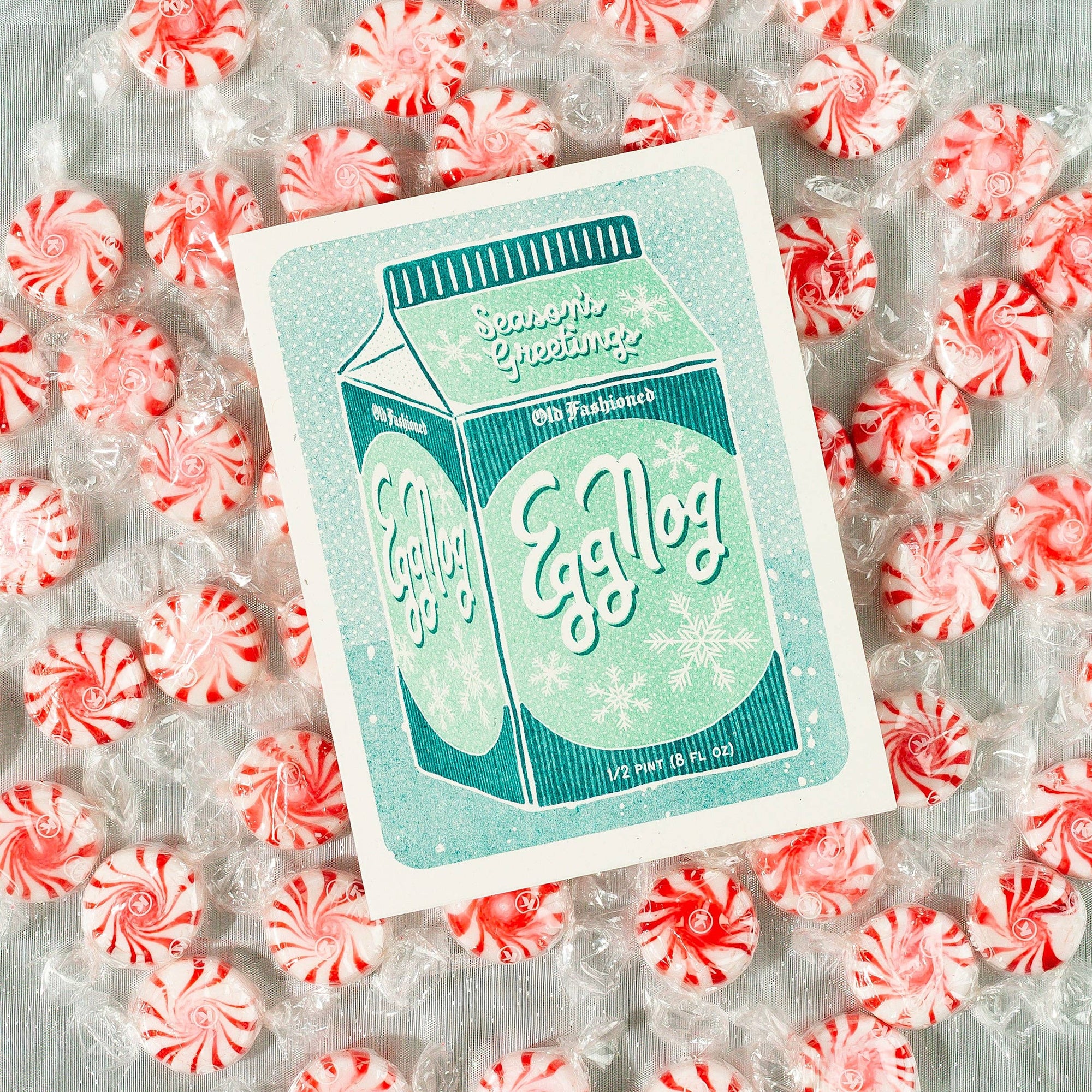 Egg Nog packaging with peppermint candies on a textured background