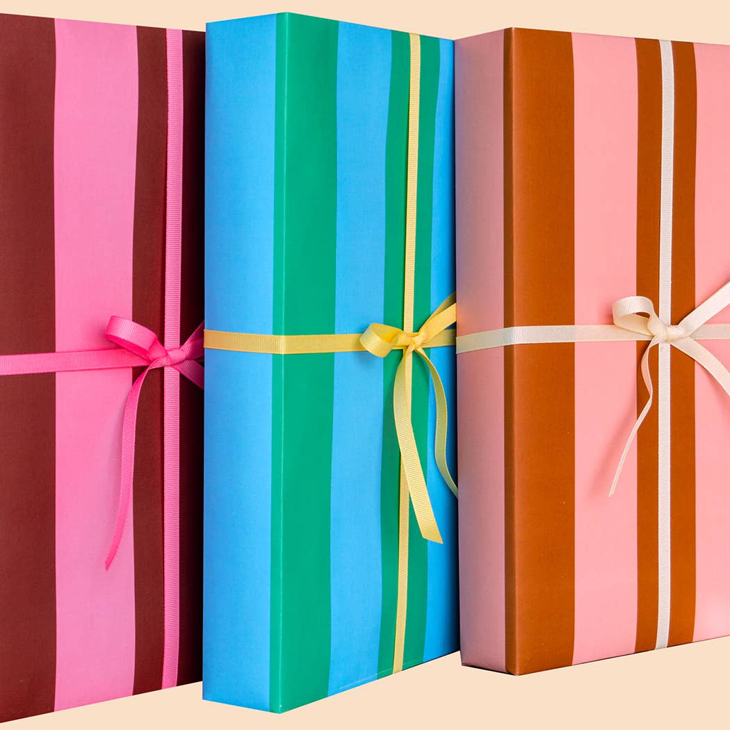 Three colorful gift boxes with ribbons on a beige background