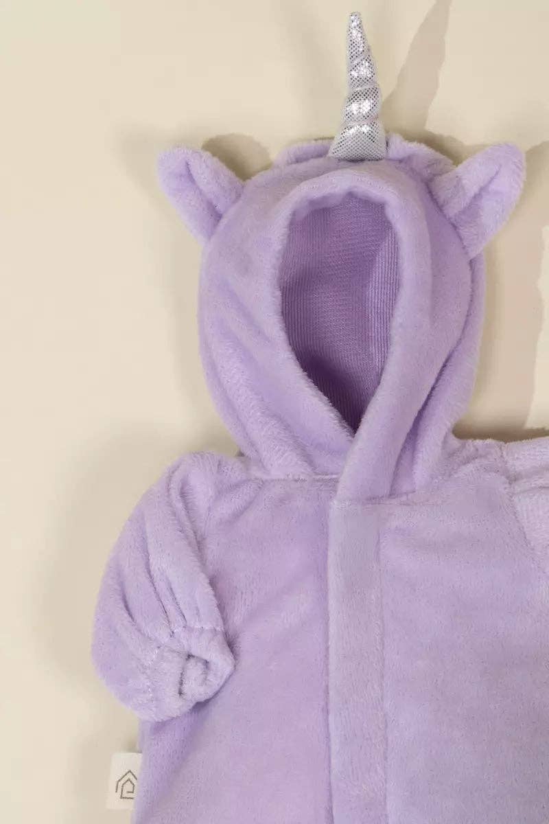 Purple unicorn costume with a silver horn on a beige background