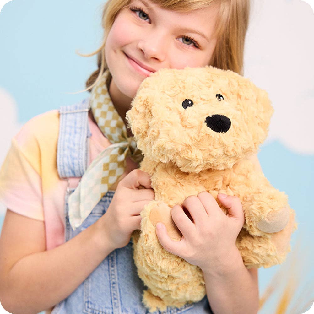 Child holding a teddy bear against a light blue background