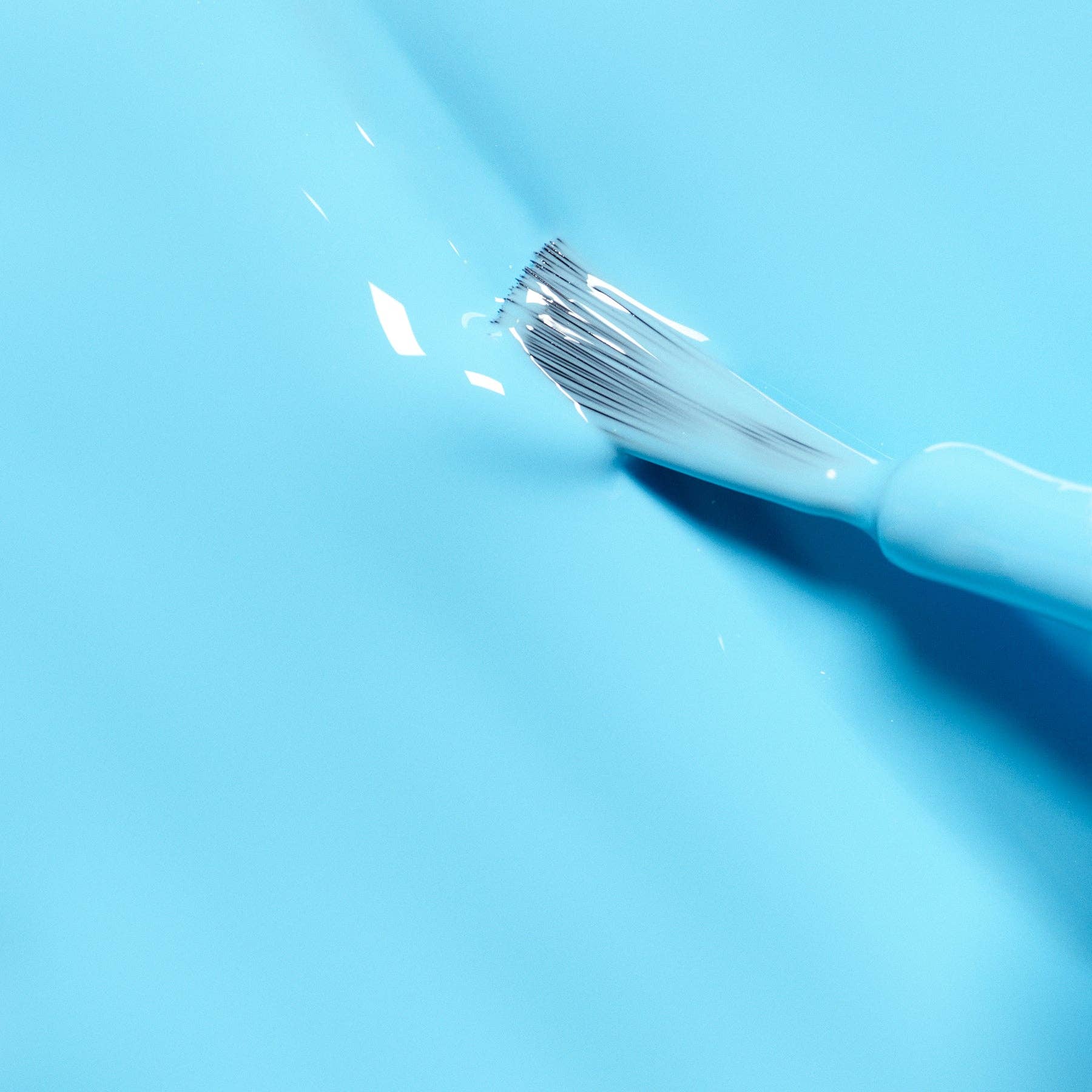 White makeup brush on a light blue background