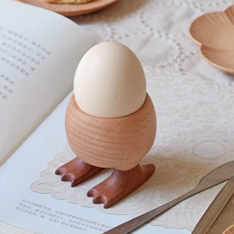 Wooden egg holder with an egg on a book