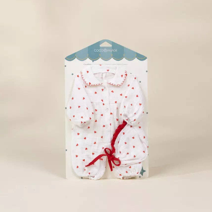Packaged baby romper with red bow on a beige background