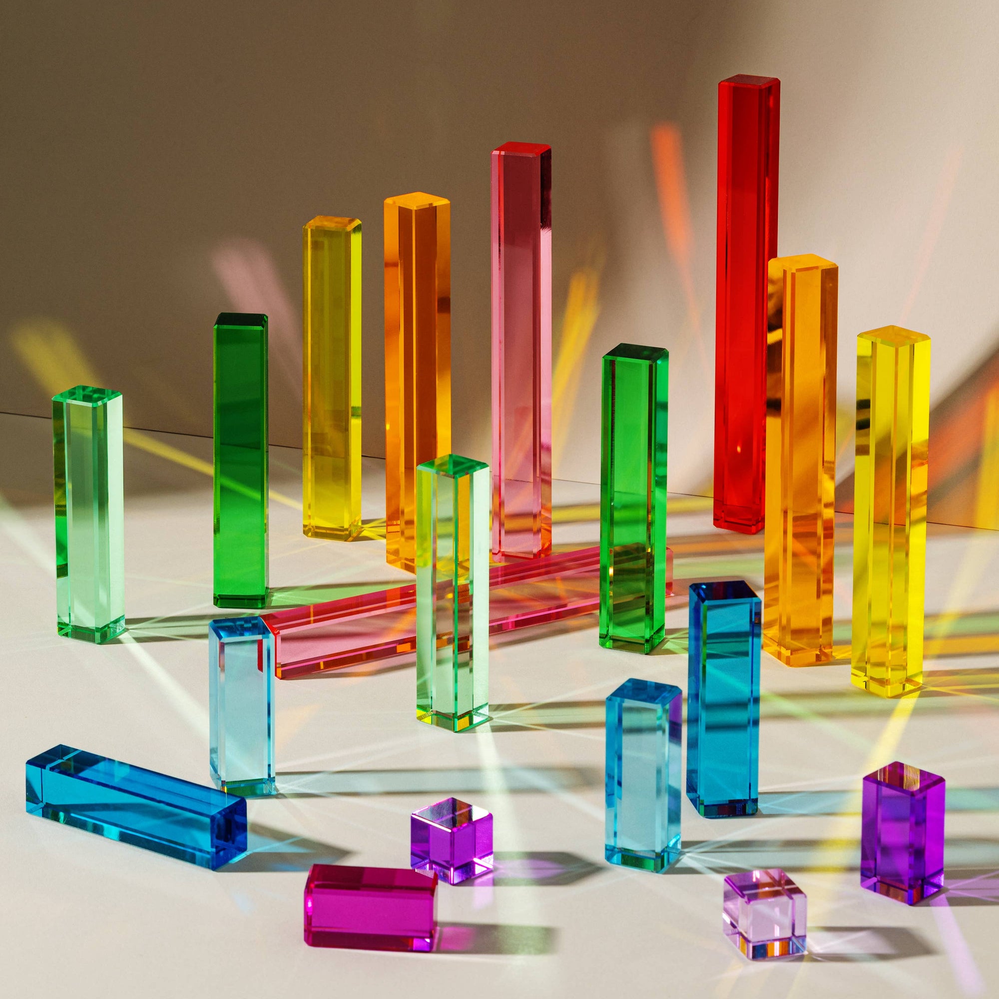 Colorful transparent acrylic blocks on a reflective surface with a blurred background