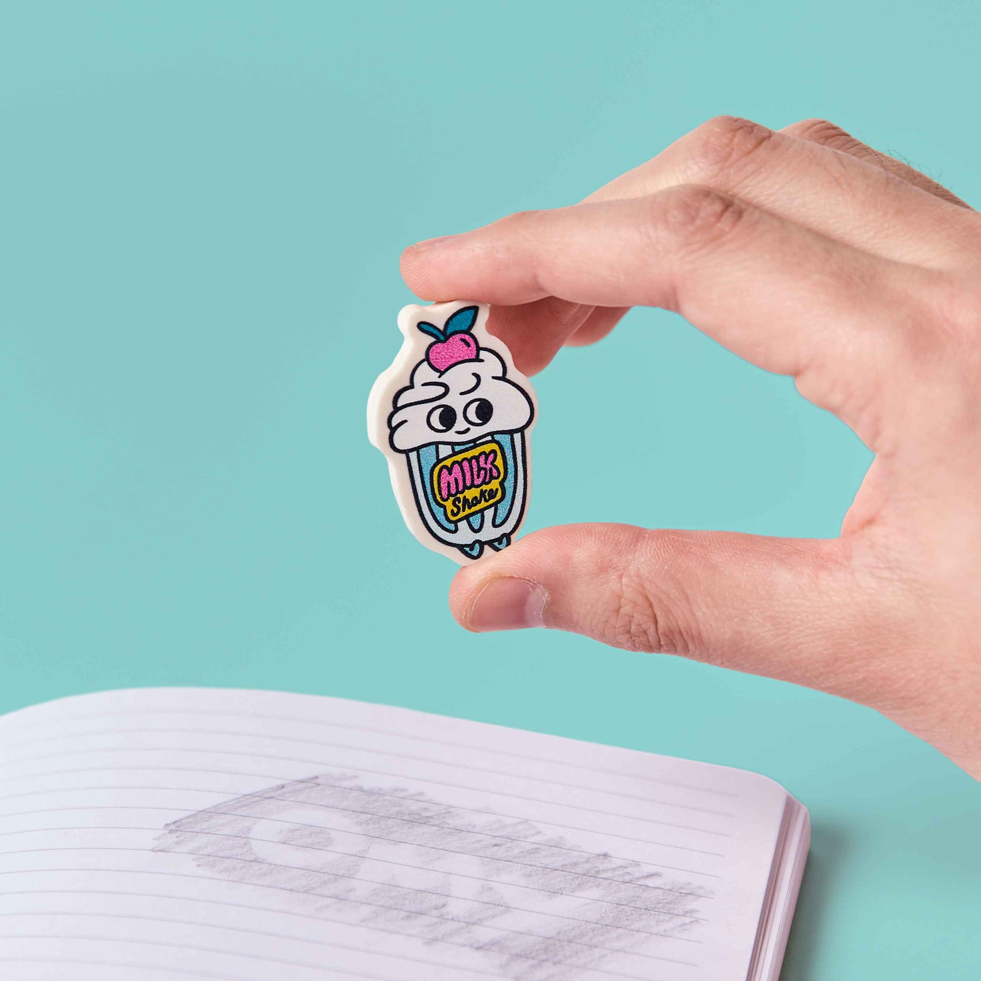 Hand holding a cartoon ice cream sticker with a blue background