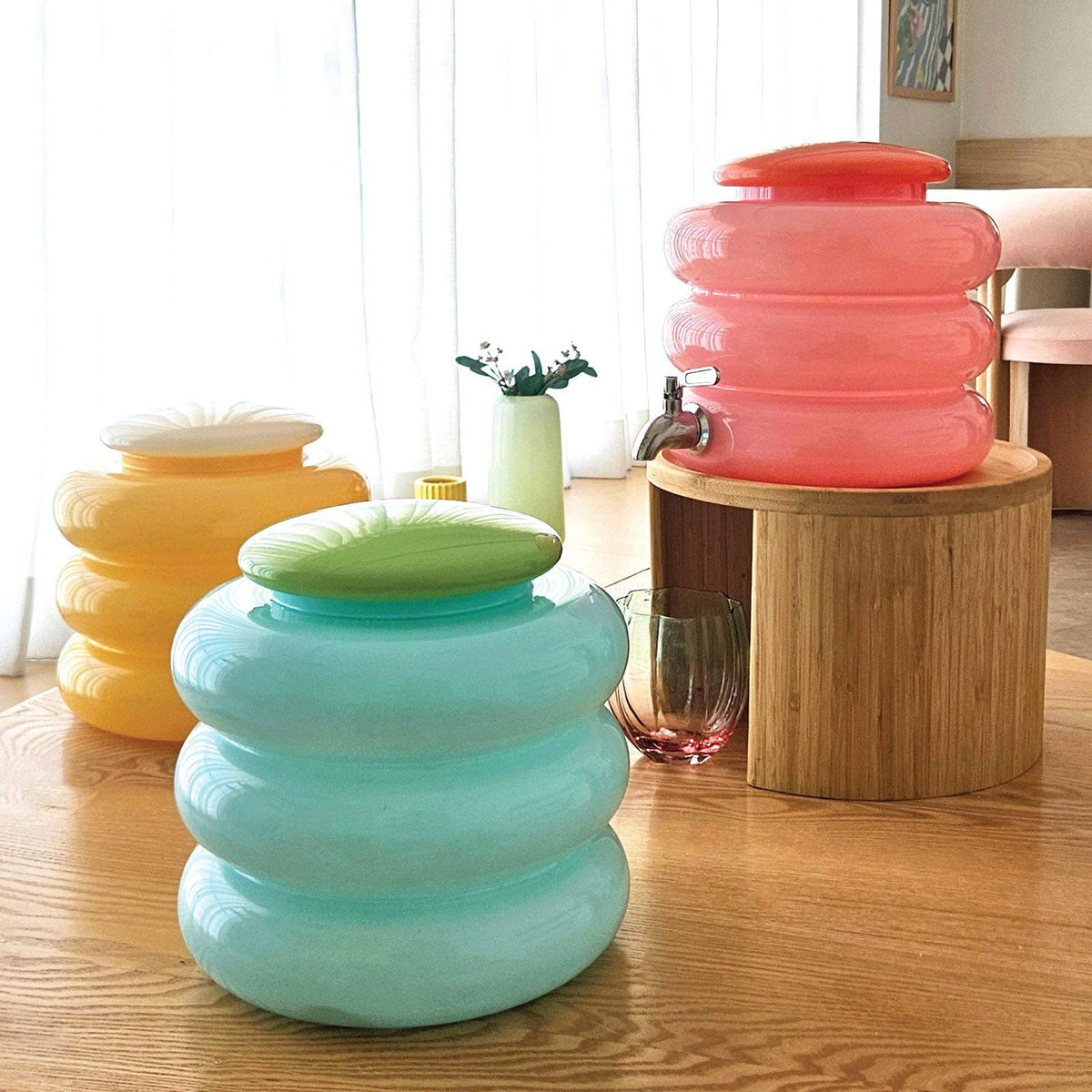 Collapsible stools in various colors on a wooden table.