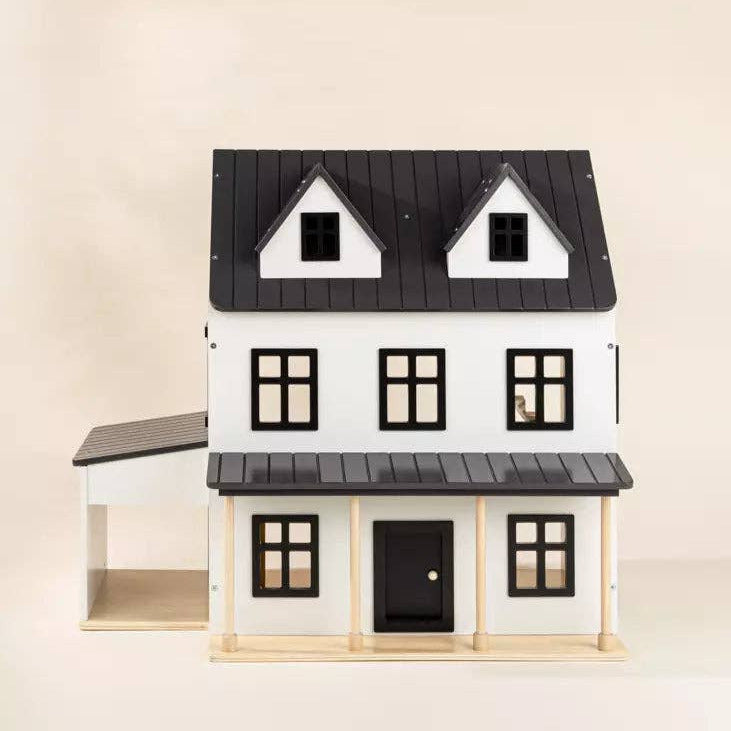 Model of a house with black roof and white walls on a beige background