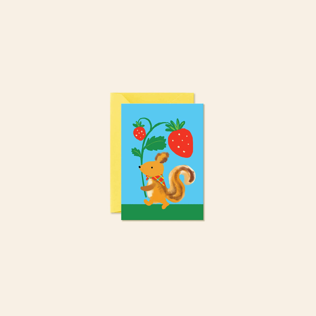 A square greeting card with a colorful illustration of a squirrel holding a strawberry plant, shown with a yellow envelope behind it on a light beige background.