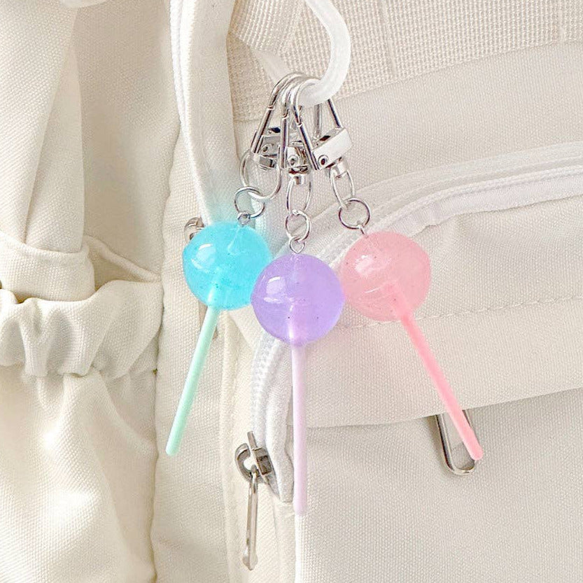 Pastel-colored lollipop keychain attached to a white bag.