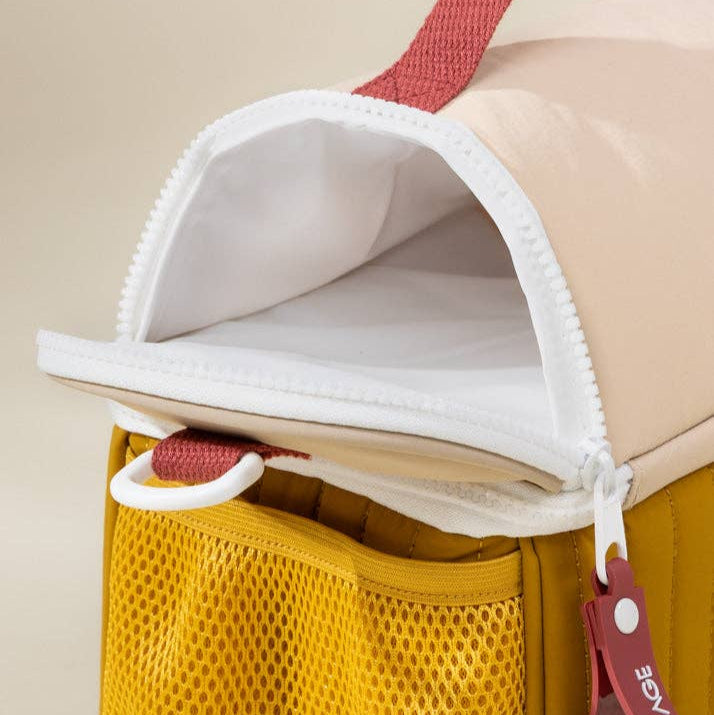 Multicolored bag with a yellow pocket and red handle on a beige background