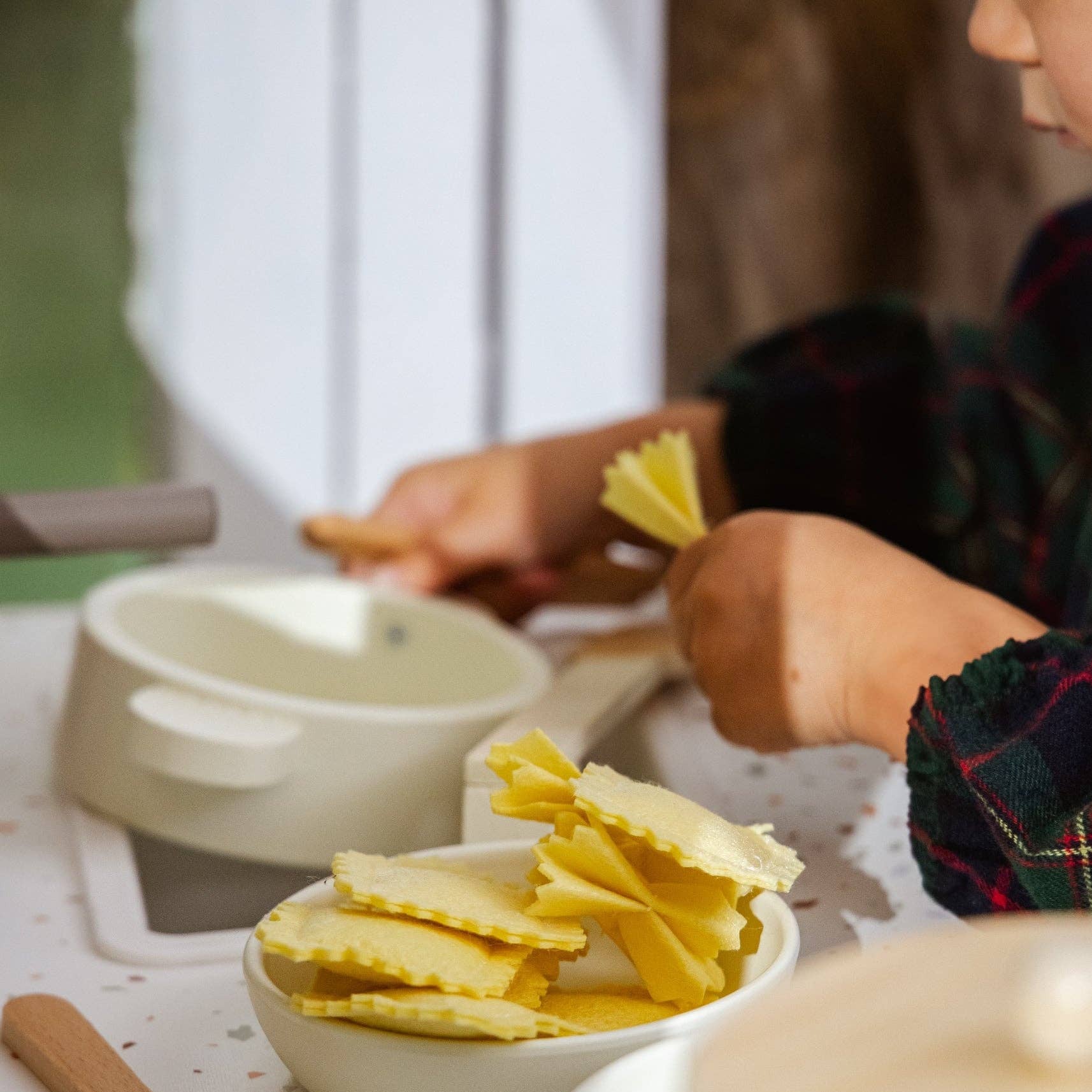 Children's play kitchen set with toy food and utensils on a table.
