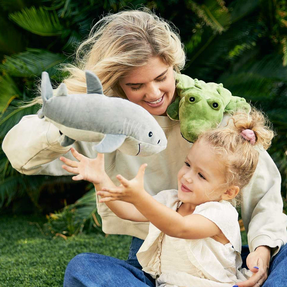 Woman and child playing with plush toys in a garden setting