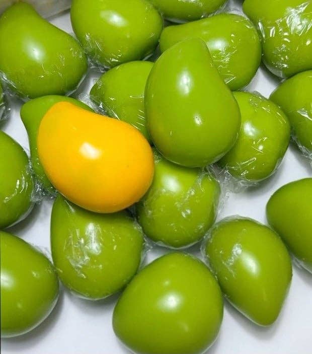 Green and orange mango-like objects on a white background