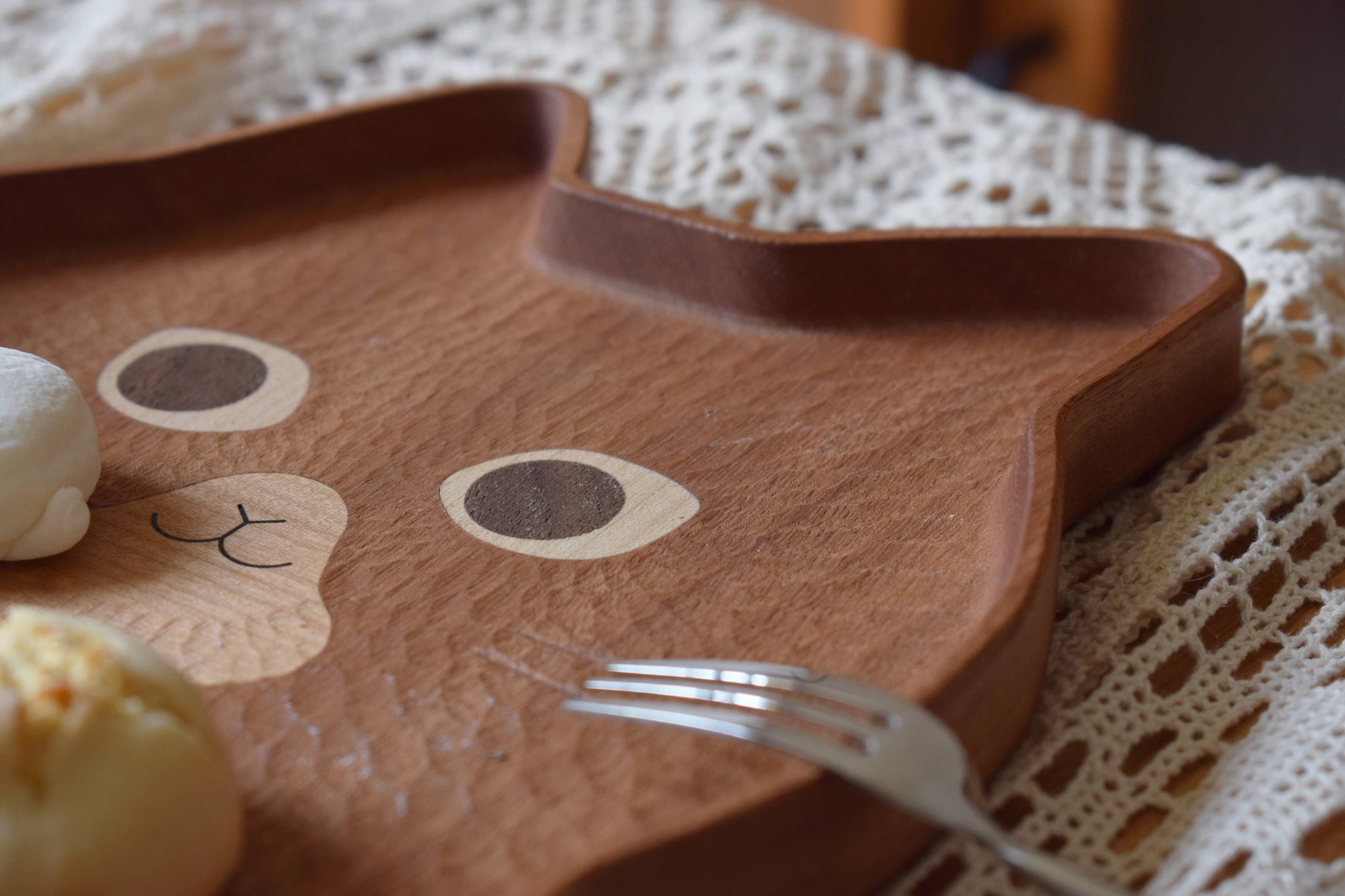 Wooden tray with cat design on a textured surface