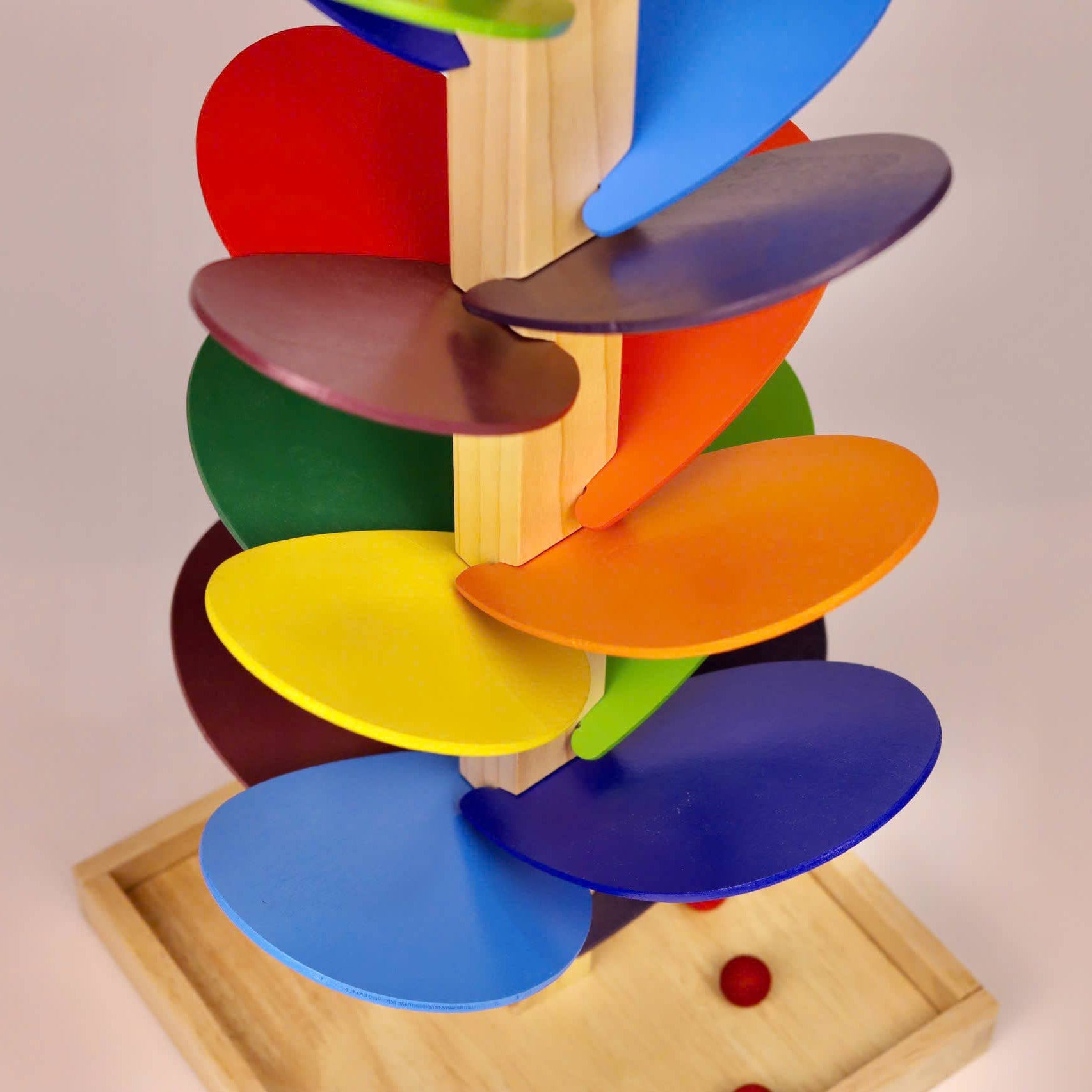 Colorful wooden toy with spinning discs on a beige background
