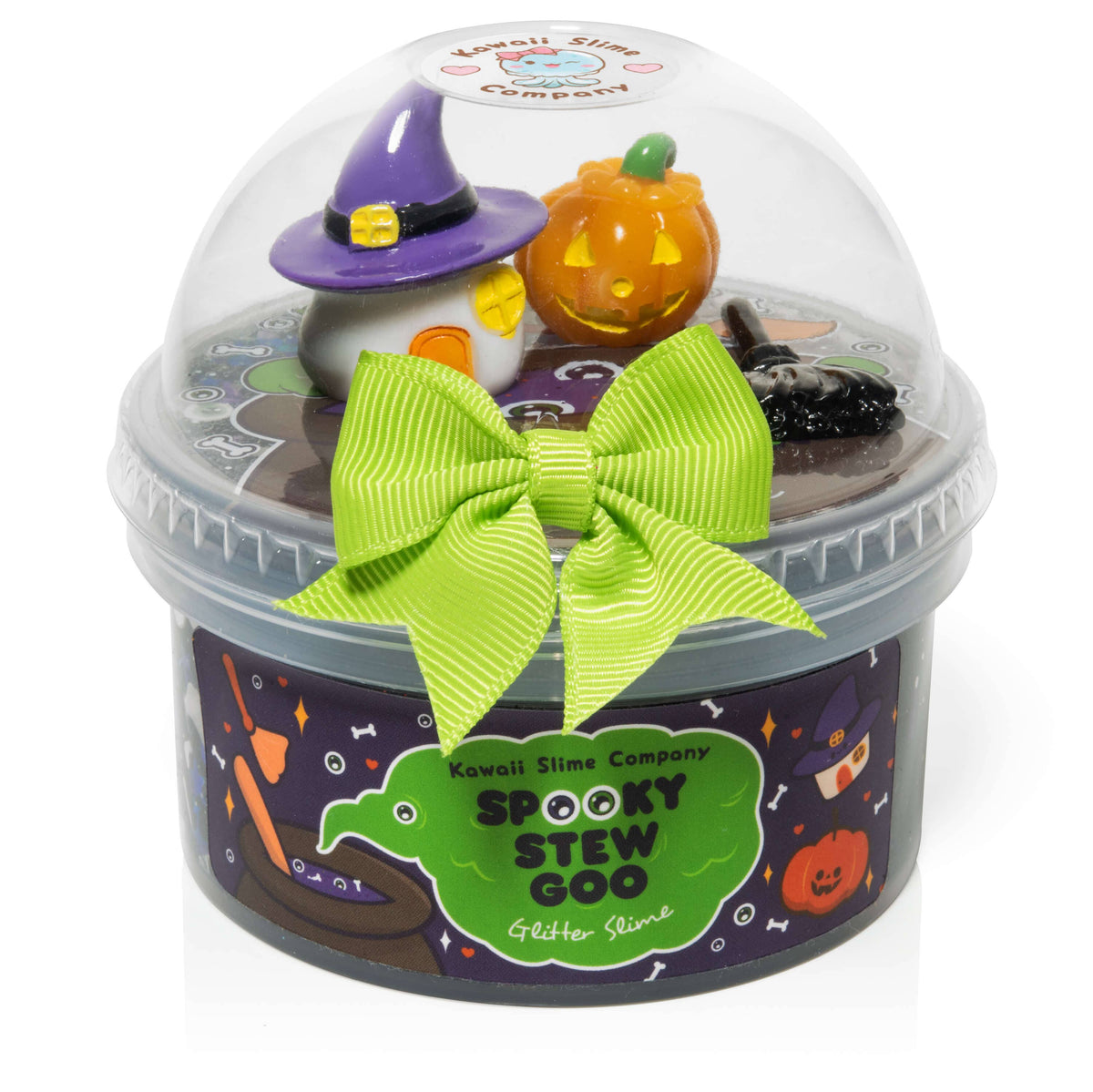 Kawaii Slime Company 'SPOOKY STEW GOO' Glitter Slime in a clear dome-topped container with a black base, decorated with a bright green ribbon bow and miniature Halloween-themed figures including a witch hat and orange pumpkin.