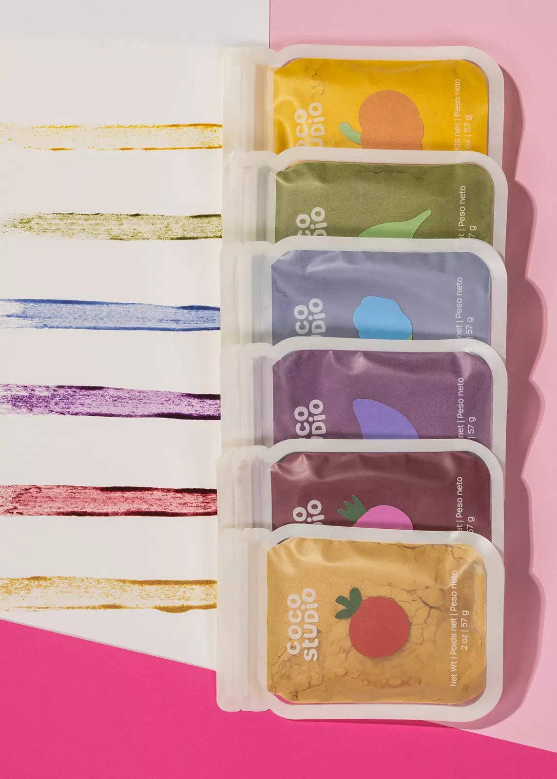 Set of colorful facial mask packets on a pink background