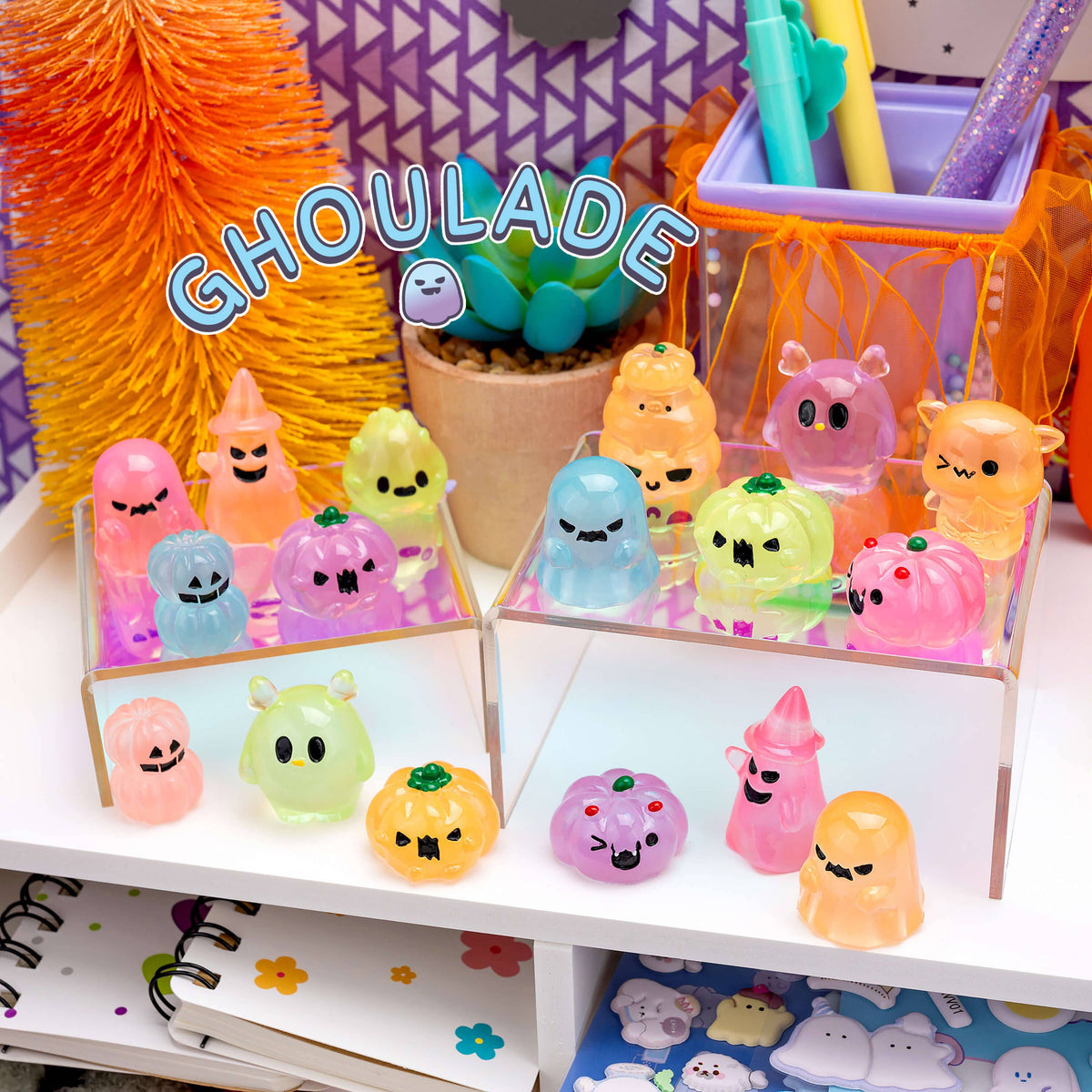 Colorful ghost-shaped desk accessories on a shelf with 'Ghoulate' branding.