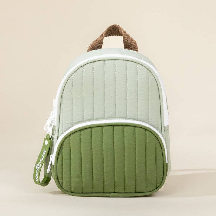Green and white backpack with brown handle on a beige background