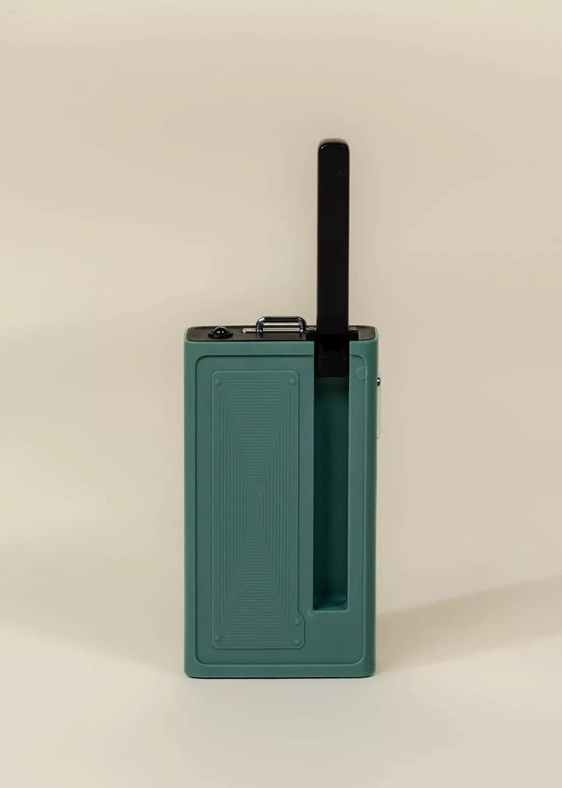Green electronic device with a black antenna on a beige background