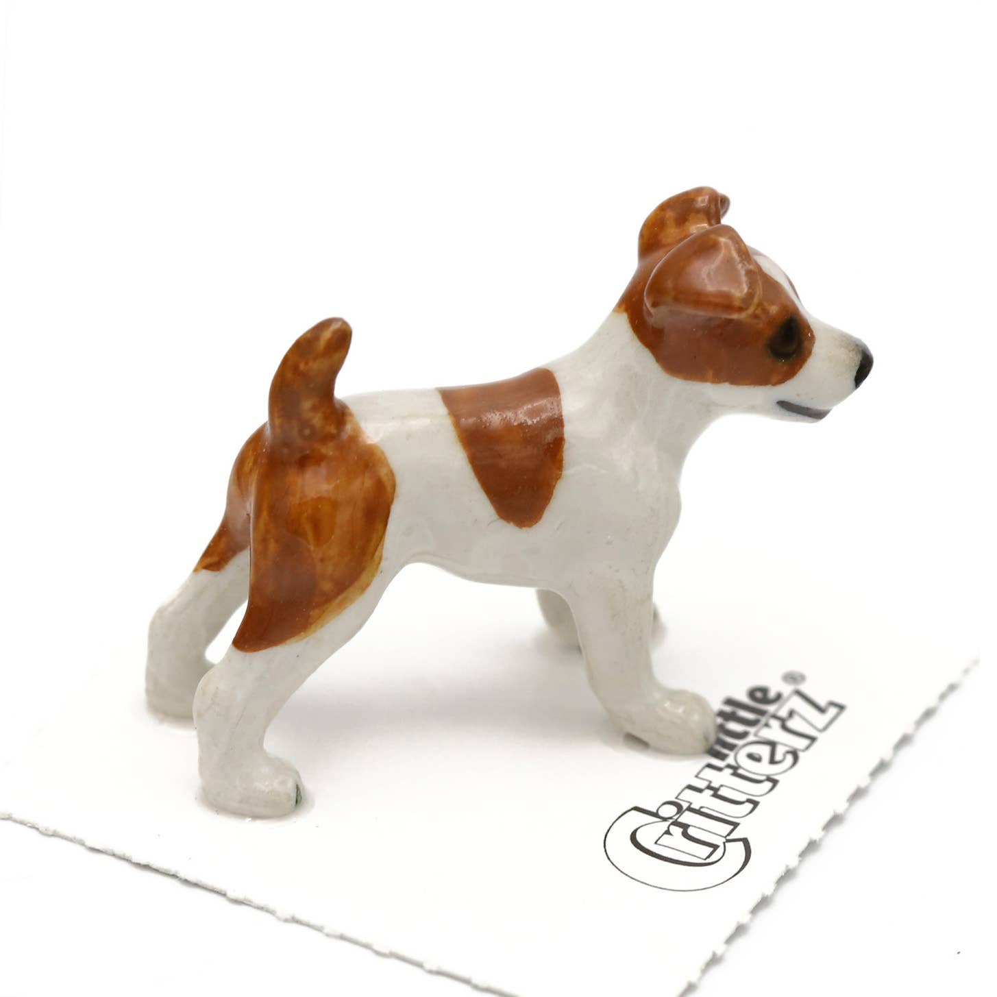 Dog figurine with brown and white markings on a white background, featuring the Little Critterz brand.