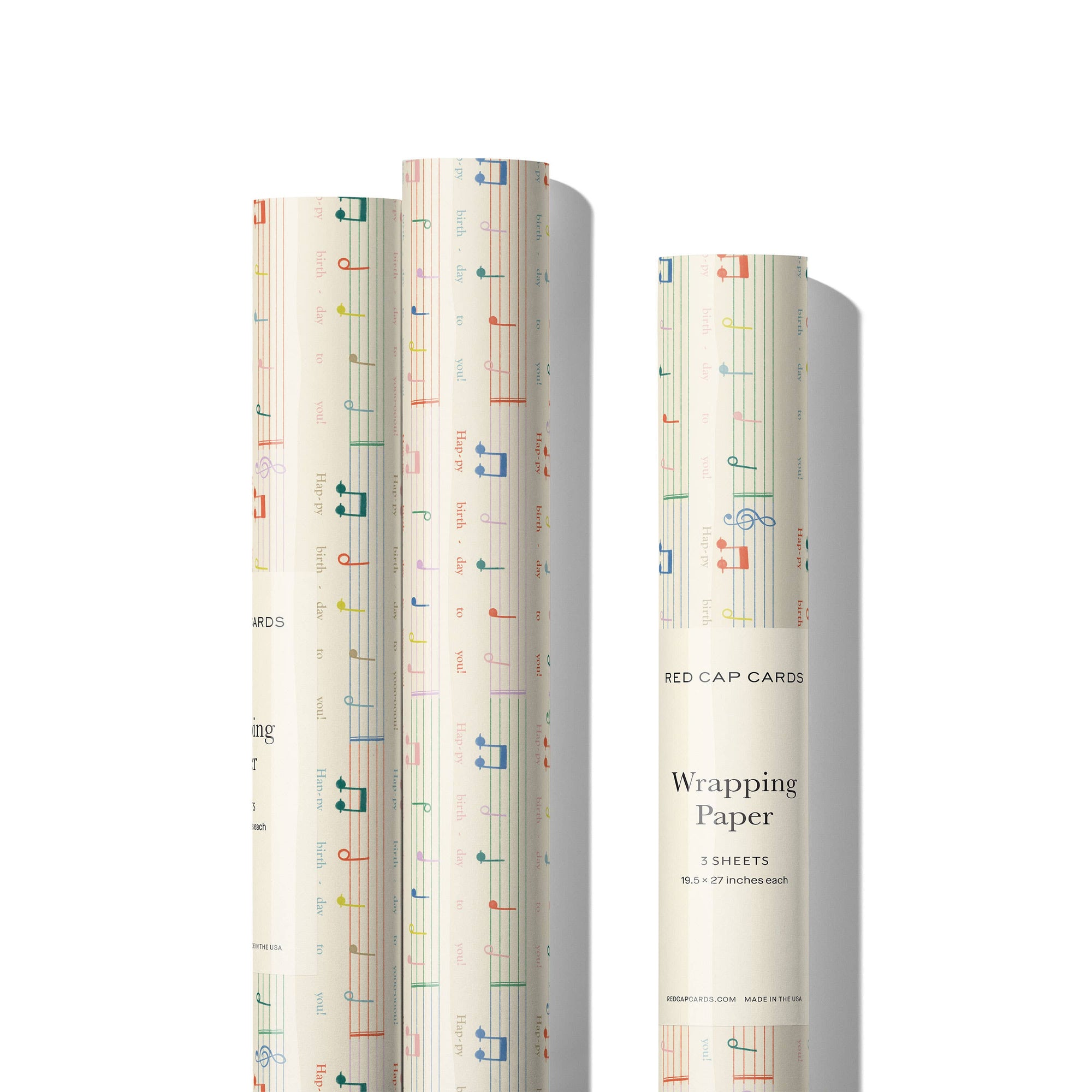 Two rolls of wrapping paper with a pattern and a box labeled 'Red Cap Cards Wrapping Paper' on a white background.