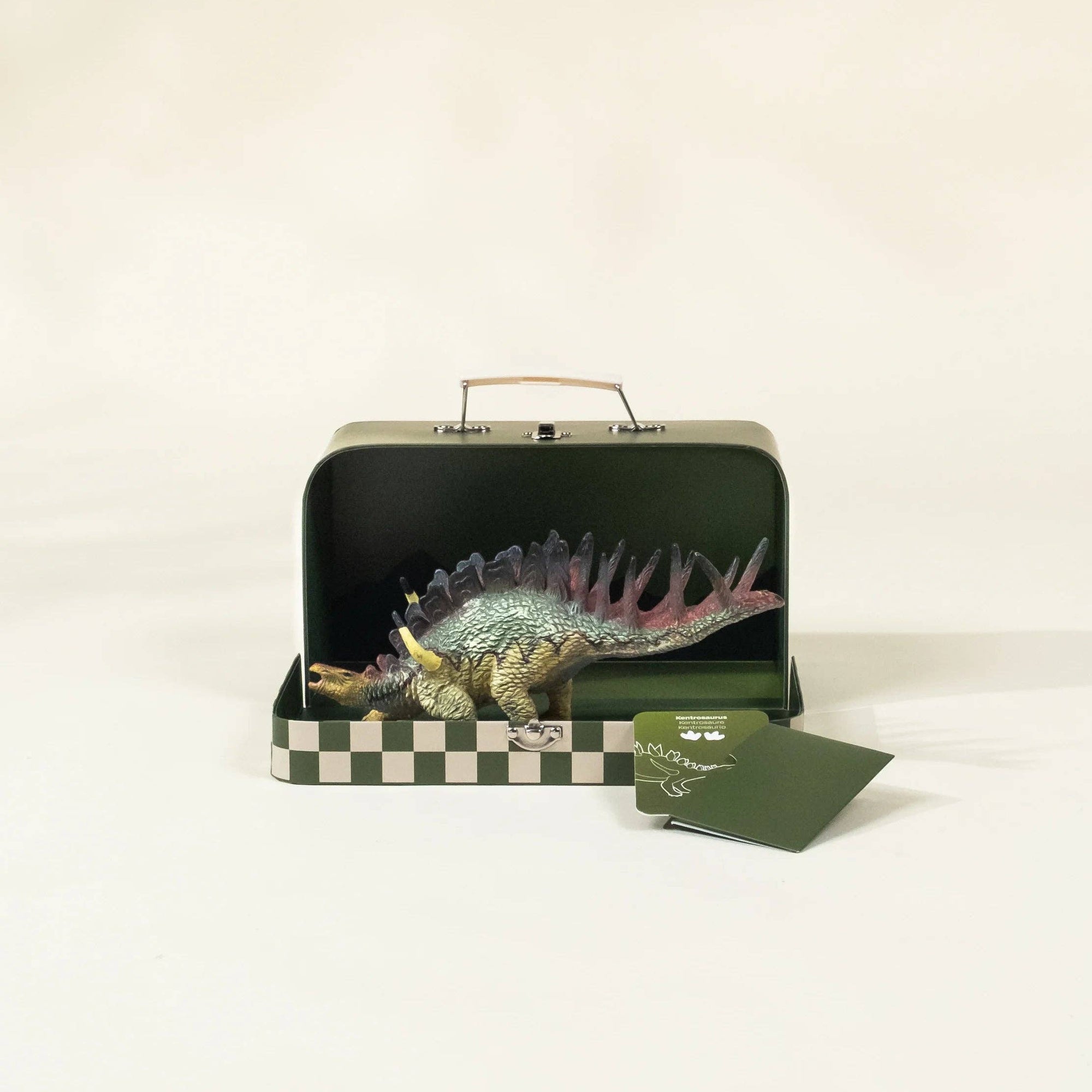 Dinosaur model in a green box with a checkered base on a white background