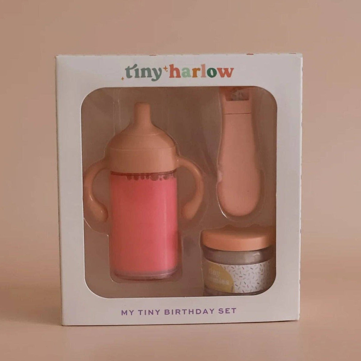Baby bottle set with packaging labeled 'tiny harlow' on a beige background