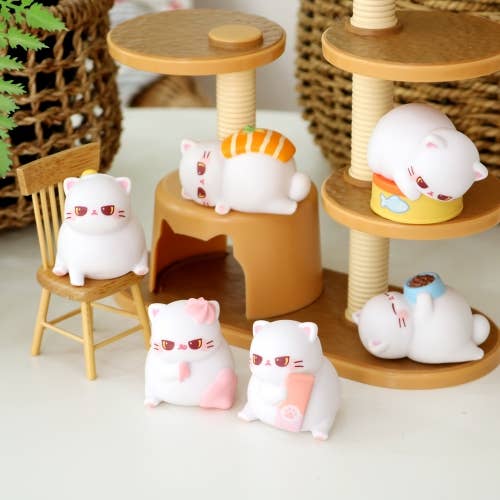 Set of cute cat-shaped figurines on a wooden stand and chair.