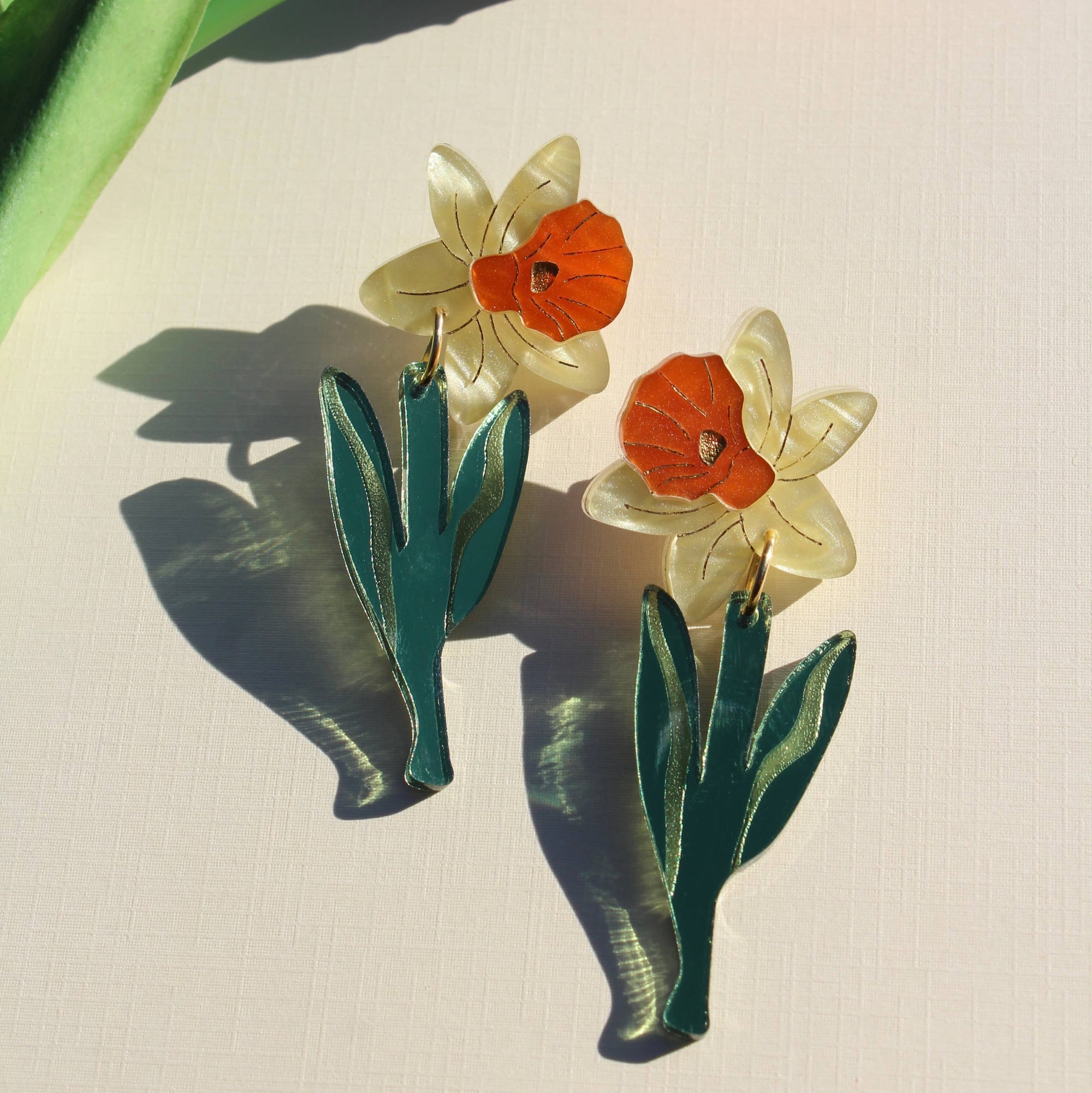 Floral earrings with orange and white flowers on a light background