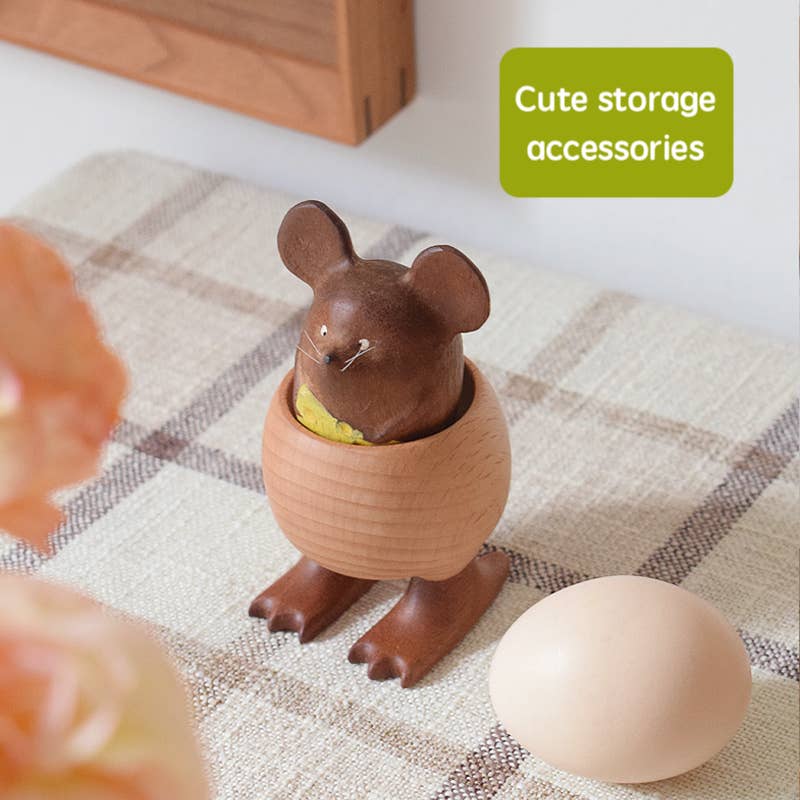 Cute mouse-shaped toy in egg holder on a checkered cloth with an eggs 
