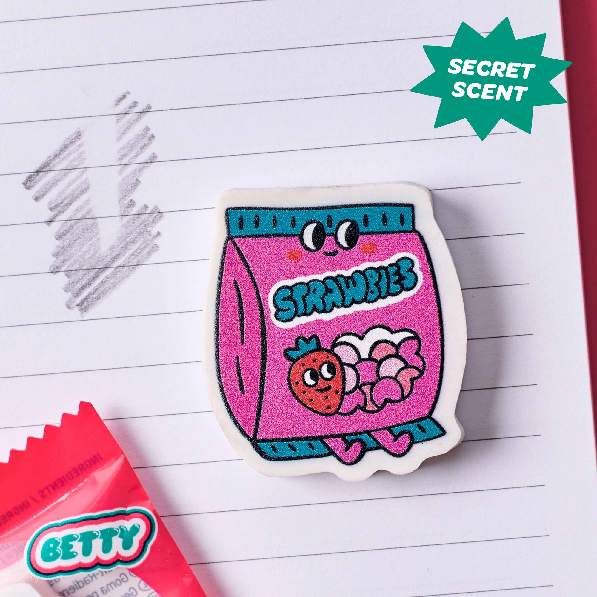 Sticker of a pink 'Strawbies' package with a cartoon strawberry on a lined paper background.