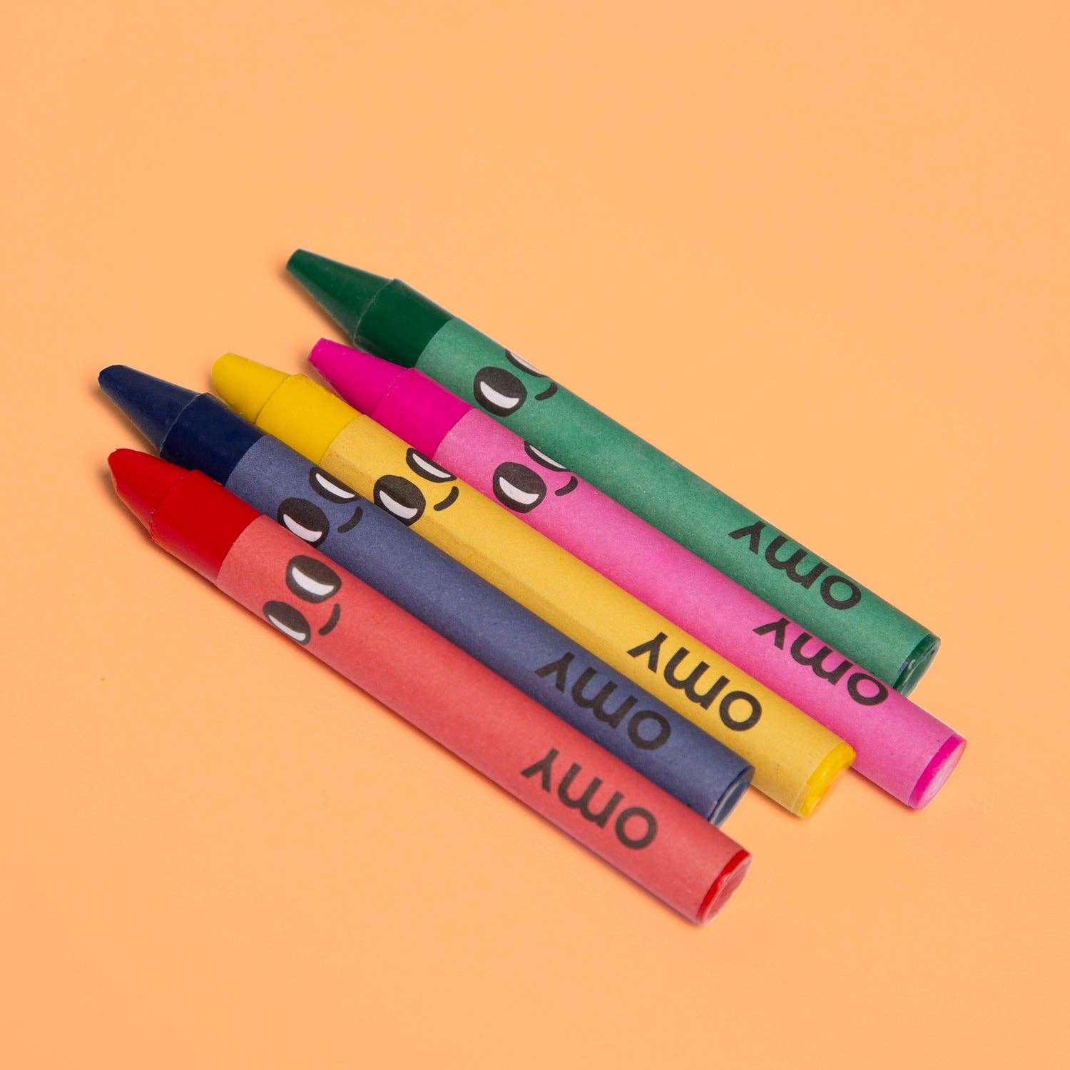 Colorful crayons with cartoon faces on an orange background