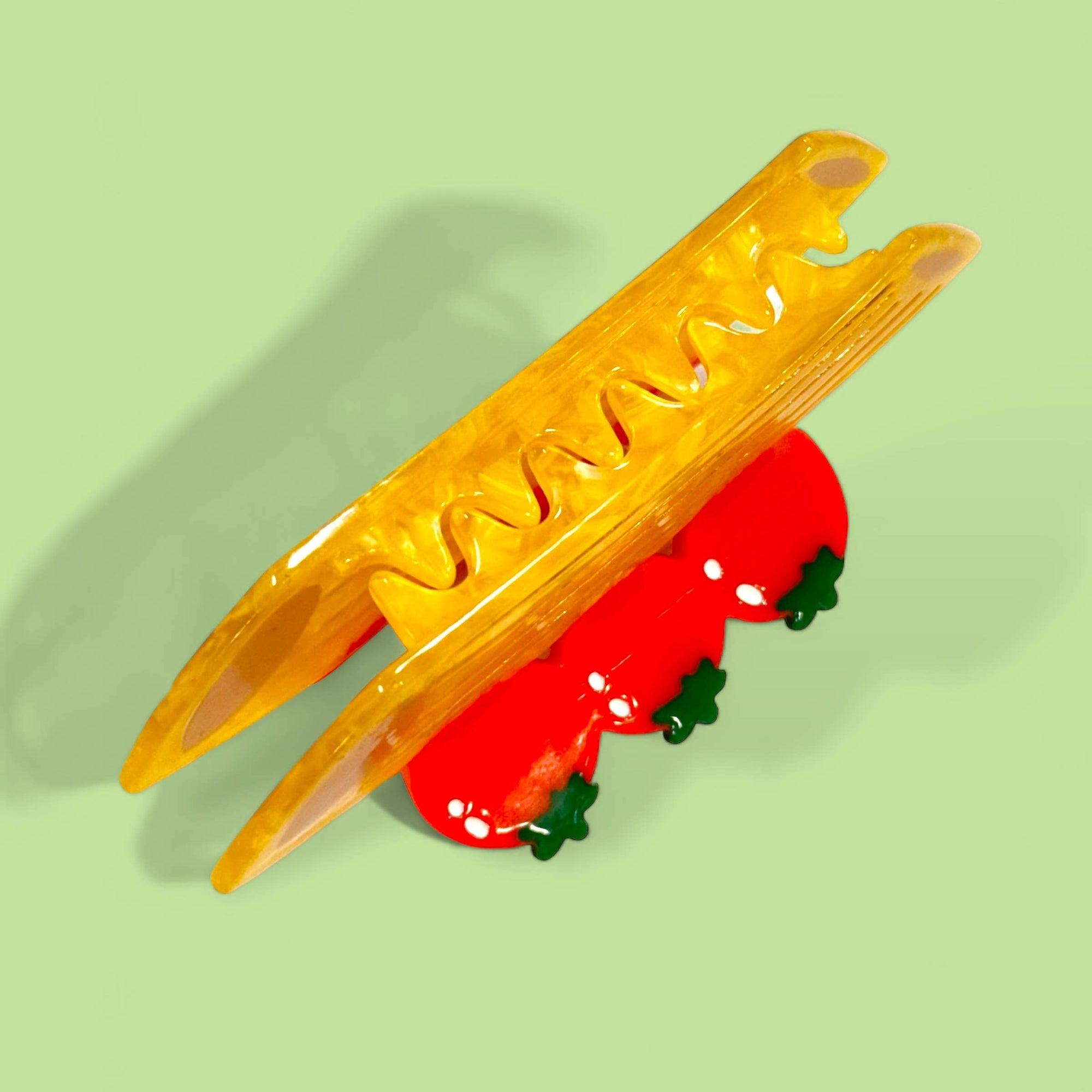 Yellow plastic tool with red object on a green background