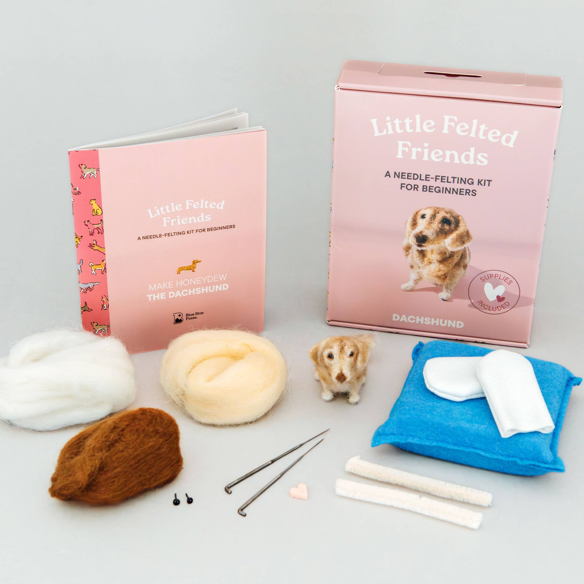 Needle-felting kit with materials and instructions on a gray background