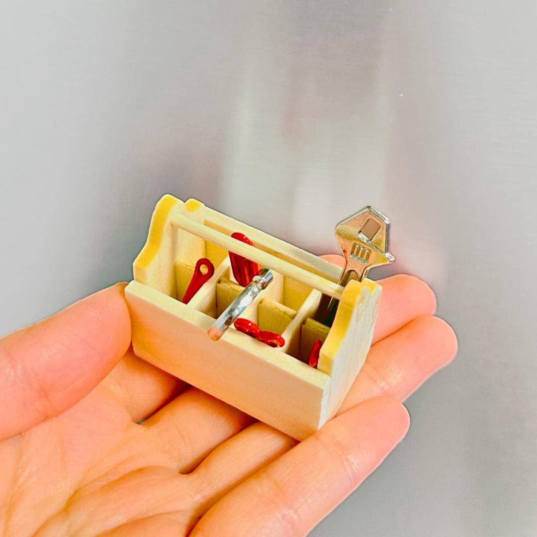Small mechanical device held in a hand against a neutral background