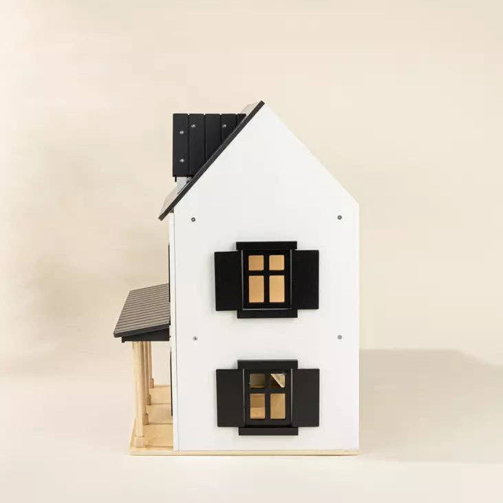 Model of a house with black shutters on a beige background