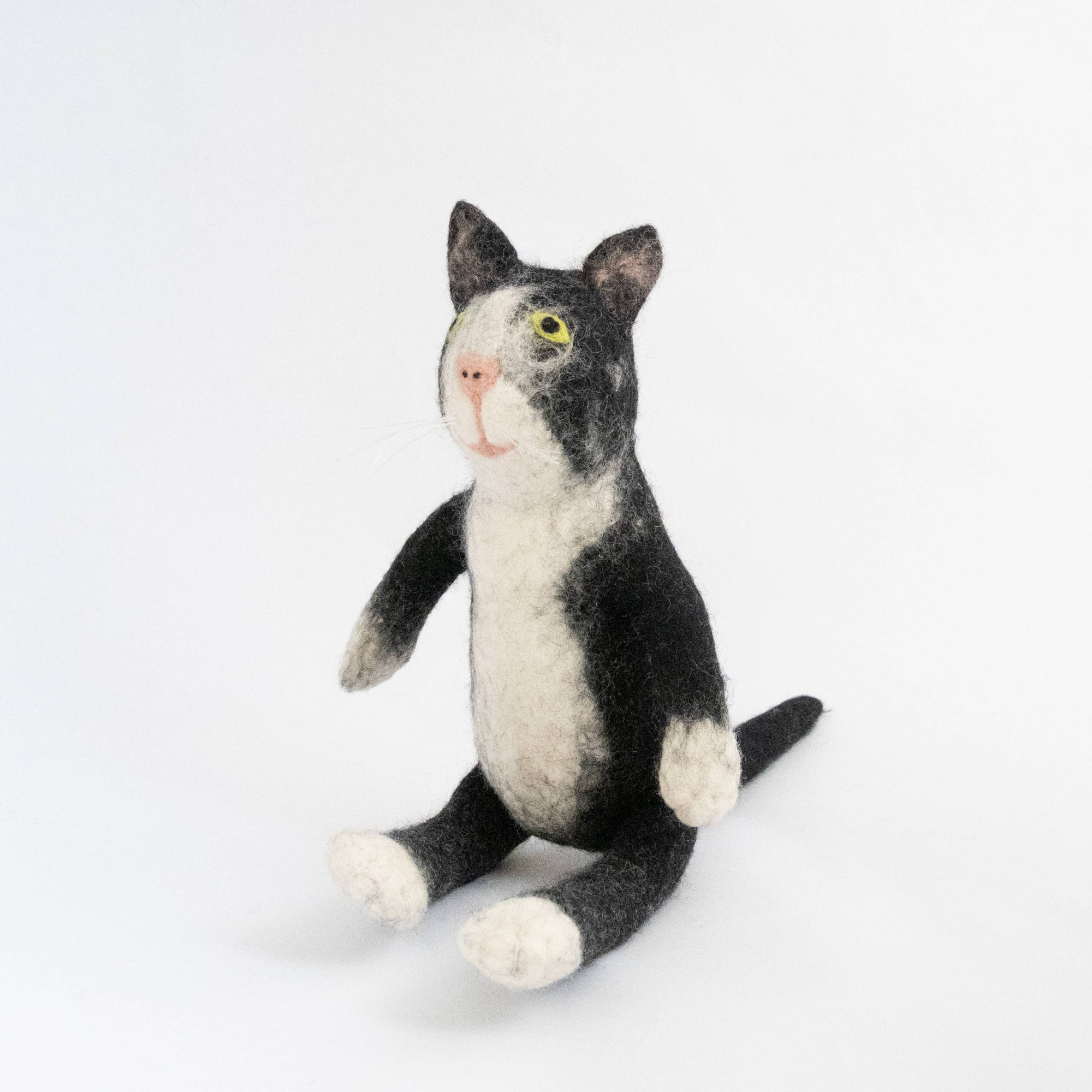 Black and white cat-shaped plush toy on a light gray background