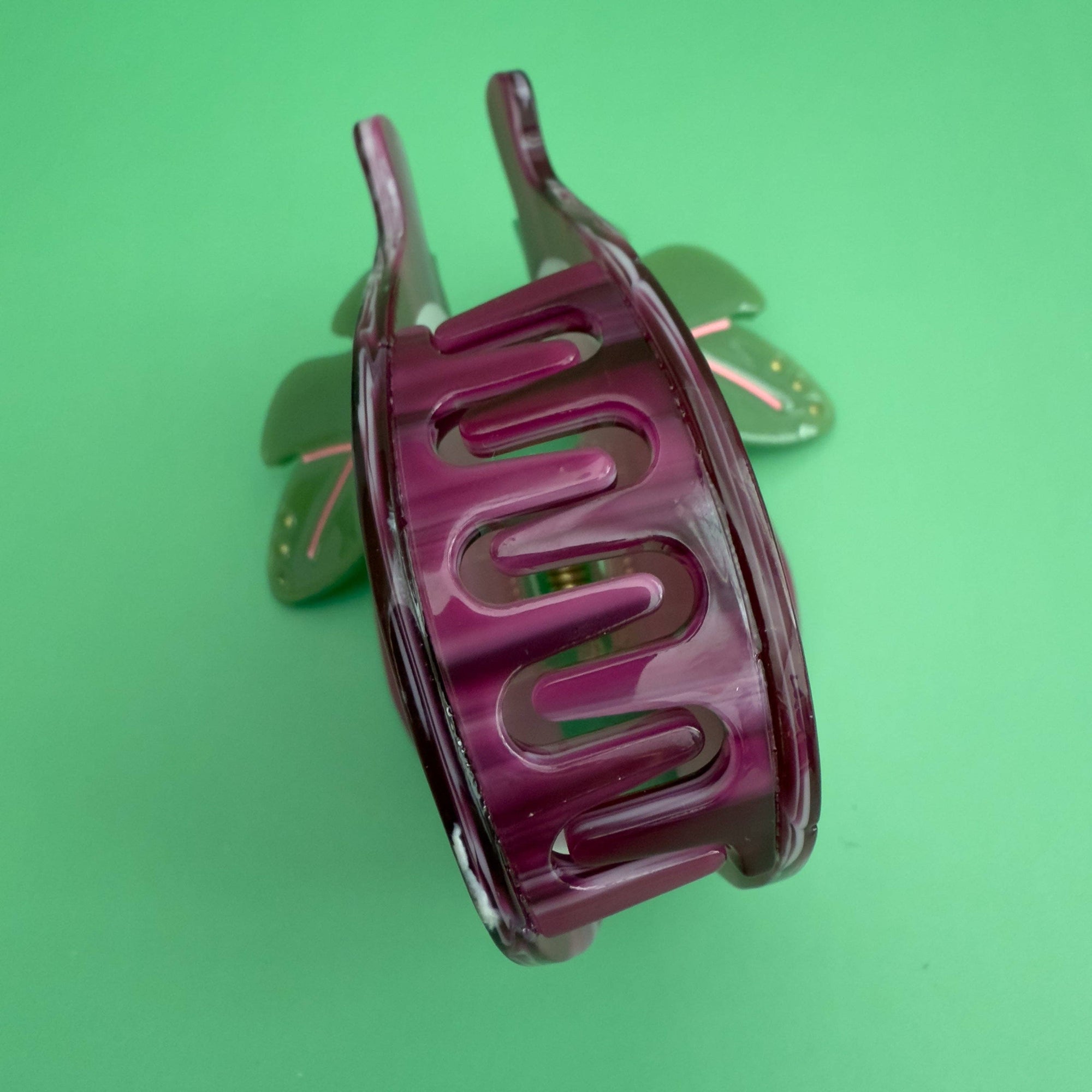 Pink hair clip on a green background