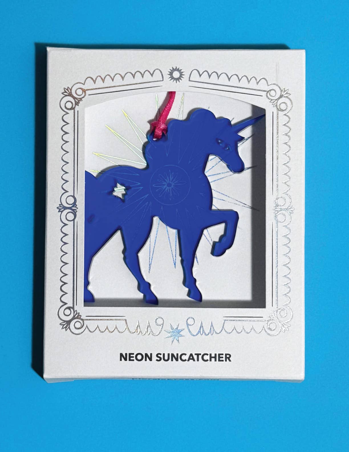 Neon suncatcher with unicorn design in packaging on a blue background